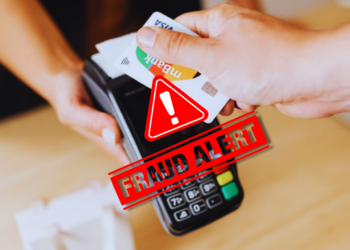 A fake credit card tapped in a machine, depicting a merchant fraud in action
