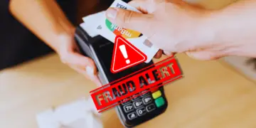 A fake credit card tapped in a machine, depicting a merchant fraud in action