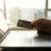 A man holding a credit card as he tries to commit fraud to a high-risk merchant account
