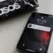 Stock photo of a smartphone lock screen showing a notification reading “ASOS: We’ve been hacked” with a red warning triangle icon, resting beside a black ASOS shopping bag and a notebook, illustrating a data breach notification.