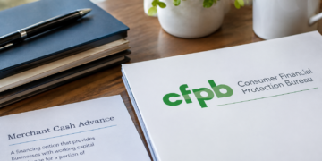 A professional office desk featuring a Consumer Financial Protection Bureau (CFPB) folder beside a document labeled “Merchant Cash Advance,” notebooks, a pen, and a potted plant, illustrating the CFPB’s reaffirmation that merchant cash advances remain excluded from Section 1071 small-business lending data reporting requirements.