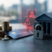 Stock photo of stacked coins, a credit card, a padlock, and a miniature bank building on a dark surface, with red holographic icons of a hooded figure, a warning triangle, and a credit card overlaid, symbolizing financial fraud and cybersecurity threats to banking.