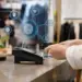 Card payment at a retail checkout with a digital overlay of connected data signals representing device fingerprinting.