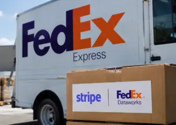 Stock photo of a FedEx Express delivery truck with a cardboard box in the foreground bearing a "Stripe | FedEx Dataworks" label, illustrating a partnership between the two companies.