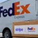 Stock photo of a FedEx Express delivery truck with a cardboard box in the foreground bearing a "Stripe | FedEx Dataworks" label, illustrating a partnership between the two companies.