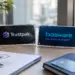 Stock photo of an office desk with two acrylic nameplates displaying the Trustpair and Basware logos, alongside a shield padlock icon, a credit card, a pen, and a document, evoking a fraud prevention and payment security partnership.